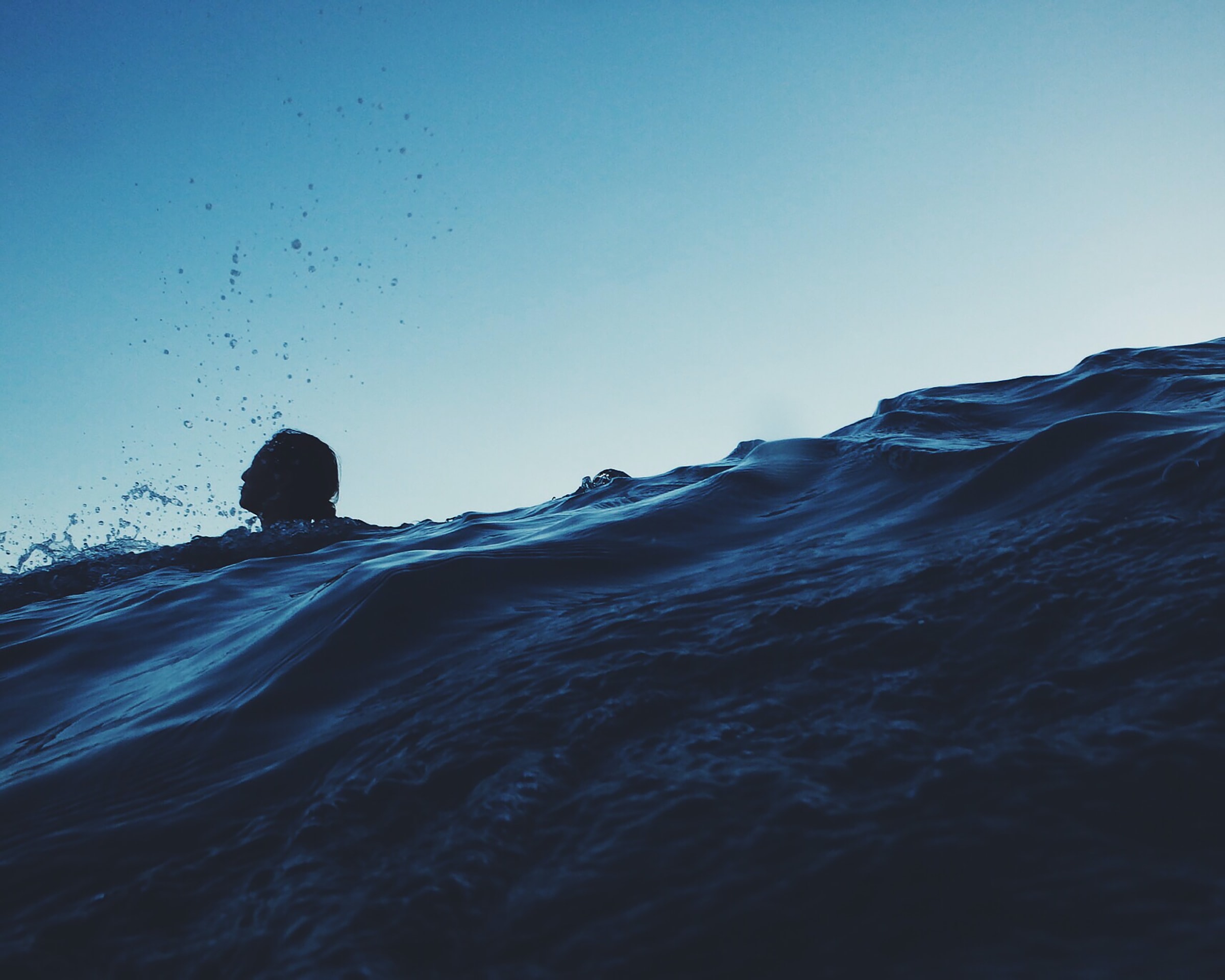 photo of person strugglng to keep their head above water in the sea