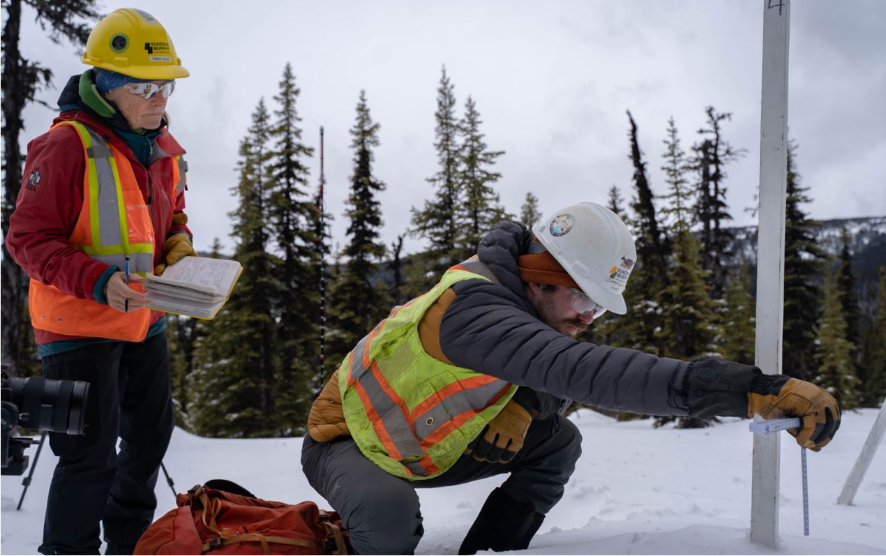 photograph of avalanche engineers measing snow depth on coastal gaslink pipeline in british colombia, canada.